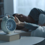 Woman waking up in the morning and alarm clock